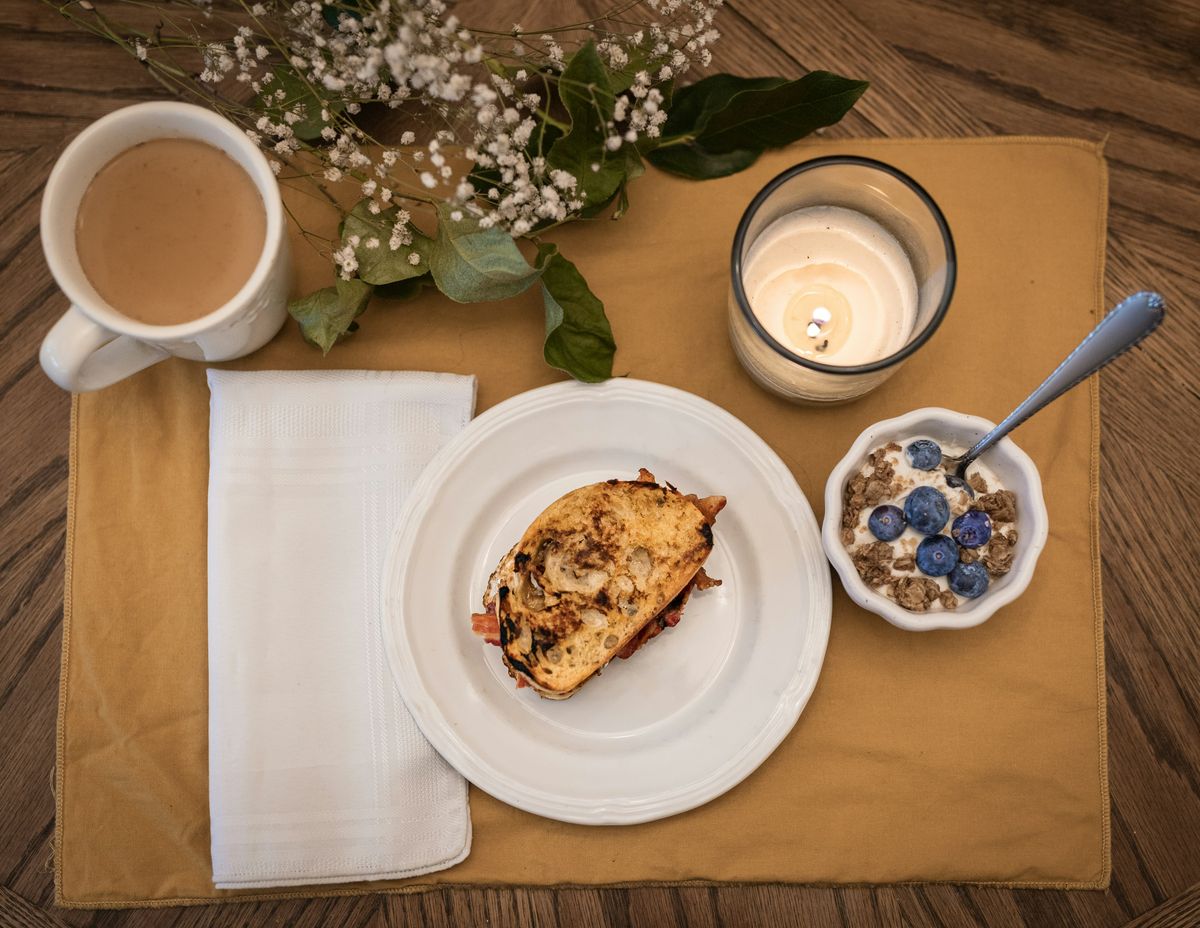 Gedeckter Frühstückstisch von oben mit Kaffee, Brot und Müesli
